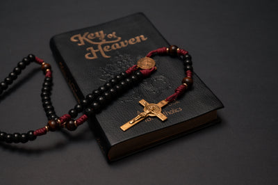 St. Benedict paracord rosary draped over a Key of Heaven Catholic prayer book